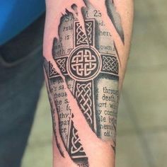 a person with a tattoo on their arm and cross in the middle of his arm