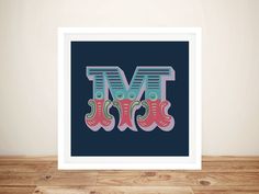 an art print with the letter m and two pink boots in front of it on a wooden floor