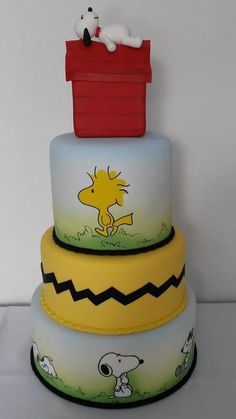 three tiered cake decorated with snoopy and charlie the pooh characters on it