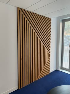 a room with blue carpet and a large wooden paneled wall next to a window