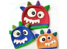 three crocheted hats with monster faces on them