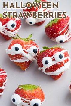 strawberries with googly eyes and white frosting on them, are arranged in the shape of monsters