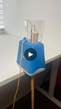 a blue blender sitting on top of a white counter next to a window sill