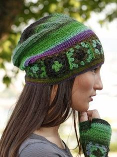 a woman wearing a knitted hat and mittens with shamrocks on it's sides