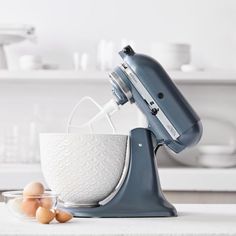 an electric mixer and eggs on a counter