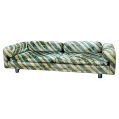 a green and white striped couch sitting on top of a wooden table