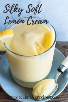 a glass cup filled with lemon cream on top of a blue plate