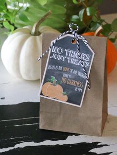 a brown paper bag with a chalkboard sign attached to it that says, no tricks just treats jesus is the light of the world