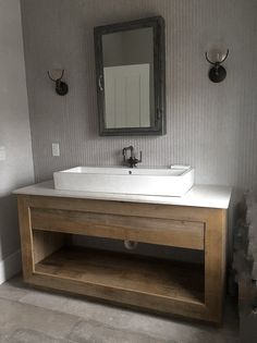 a bathroom with a sink, mirror and two wall sconces on the wall