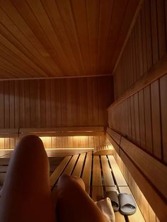 a person laying down in a sauna with their feet on the floor and lights shining