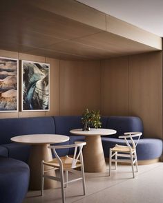 a blue couch and table in a room with wood paneling on the walls,