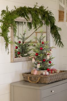 the christmas tree is decorated with red and white balls, greenery, and ornaments