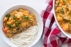 two white bowls filled with food next to a red and white towel