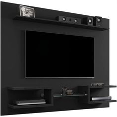 a flat screen tv mounted to the side of a black entertainment center with shelves below it