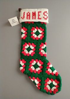 a green and red knitted christmas stocking with name janes written on it