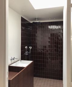 a bathroom with a sink, mirror and tiled walls