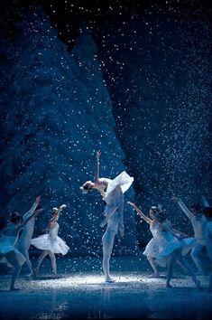 ballet dancers in white tutus and snow falling from the sky