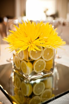 a vase filled with yellow flowers and lemons