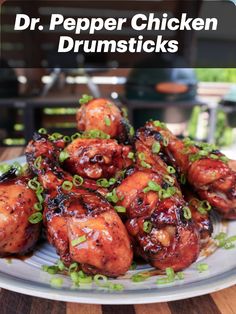 the cover of dr pepper chicken drumsticks on a plate with scallions