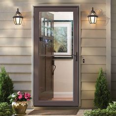 an open door on the side of a house with potted plants in front of it