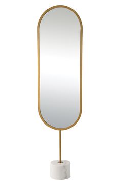 a white and gold mirror on a stand