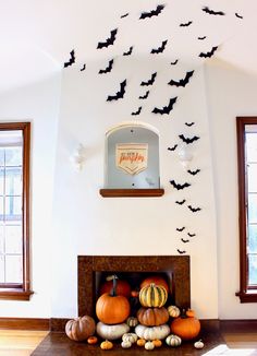 a living room filled with lots of pumpkins on top of a mantle covered in bats