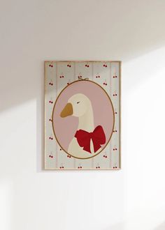 a white duck with a red bow on it's neck hanging from a wall