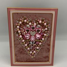 a heart shaped card with pearls and jewels