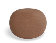 a brown round ottoman sitting on top of a white floor