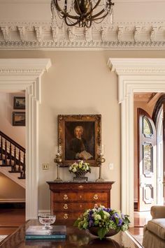 a living room filled with furniture and a painting on the wall above a coffee table