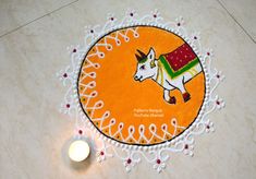 a small white candle sitting on top of a floor next to an orange and white rug