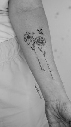 a woman's arm with three flowers on it and a butterfly sitting on the flower