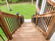 a wooden staircase with railings leading to a grassy area in the backgroud