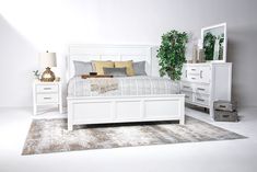 a bedroom with white furniture and plants on the side tables in front of the bed