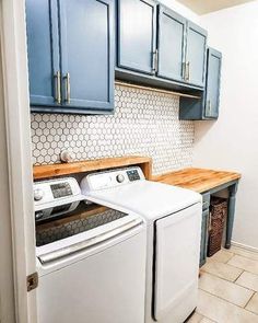 a washer and dryer in a kitchen with blue cabinets