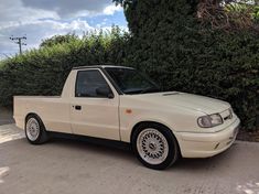 a white pick up truck parked next to a bush