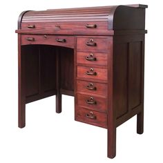 an antique wooden desk with drawers on the top and bottom drawer, in dark wood