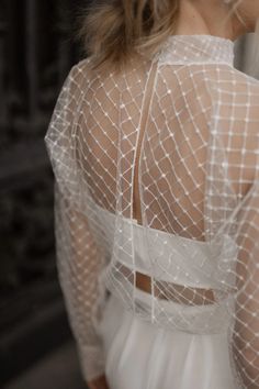 the back of a woman's wedding dress, with sheer white mesh on it