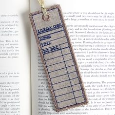 a bookmark hanging from the end of an open book, with text on it