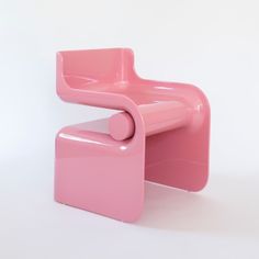 a pink plastic chair and foot stool against a white background