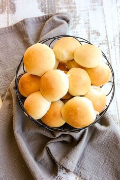 a basket filled with rolls sitting on top of a table