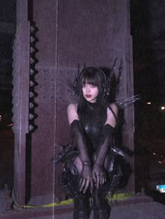 a woman in black catsuit sitting on the ground