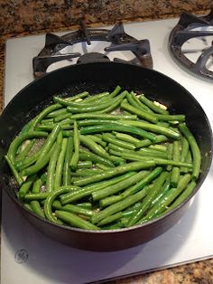 green beans are cooking in a pan on the stove top, ready to be cooked