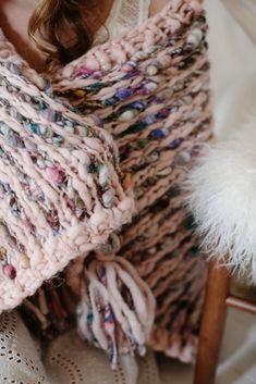 a close up of a woman wearing a knitted shawl