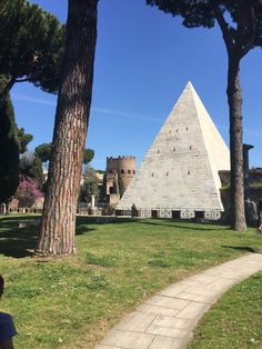 two large pyramids in the middle of a park with trees and grass around them