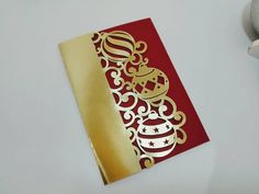 a red and gold christmas card on a white table