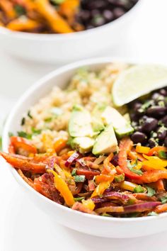 two white bowls filled with different types of salads and vegetables on top of each other