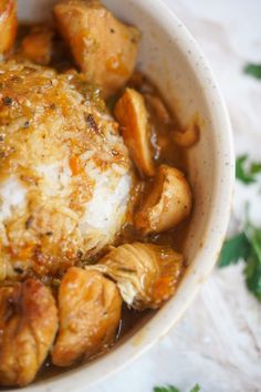 a white bowl filled with chicken and mushrooms