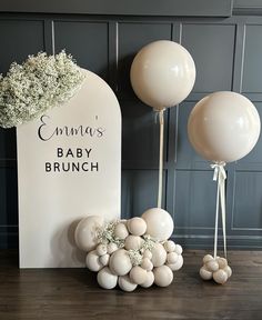 balloons and baby's breath are sitting on the floor next to a sign that says,