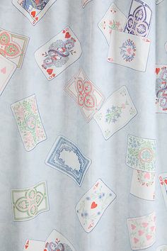 a blue shower curtain with playing cards on it's side and hearts in the middle